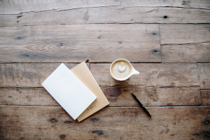 Uncropped image of coffee and notebook on a wooden table